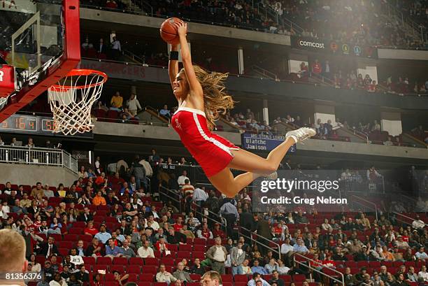 Basketball: Houston Rockets dance team cheerleader making dunk from trampoline during game vs Washington Wizards, Houston, TX 2/26/2008