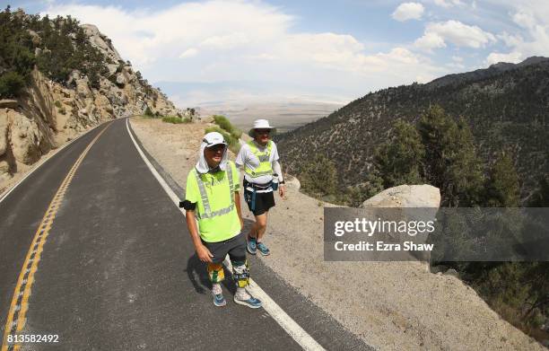 Adam Connor of Australia walks with a member of his support crew to the Whitney Portal during the STYR Labs Badwater 135 on July 12, 2017 in Death...