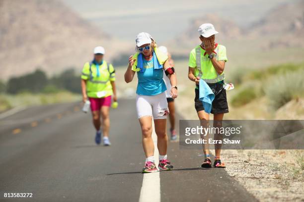 Collen Zato and a member of her support team walk to the Whitney Portal during the STYR Labs Badwater 135 on July 12, 2017 in Death Valley,...
