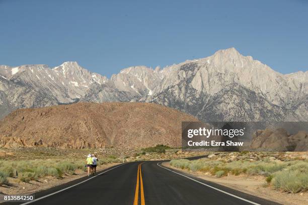 Dan McHugh runs to the Whitney Portal with a member of his support crew during the STYR Labs Badwater 135 on July 12, 2017 in Death Valley,...