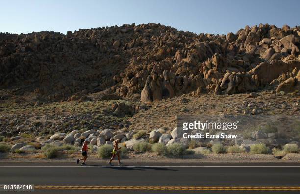 Amy Costa runs to the Whitney Portal with a member of her support crew during the STYR Labs Badwater 135 on July 12, 2017 in Death Valley,...