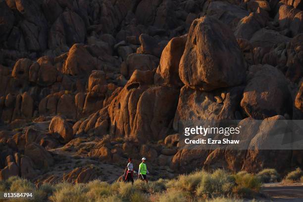 Szilvia Lubics of Hungary walks to the Whitney Portal with a member of her support crew during the STYR Labs Badwater 135 on July 12, 2017 in Death...