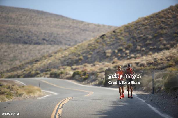Mohammad Al Swaiti of Jordann runs with a member of his support crew during the STYR Labs Badwater 135 on July 12, 2017 in Death Valley, California....