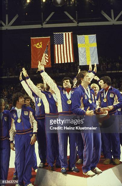 Hockey: 1980 Winter Olympics, USA Mike Eruzione and team victorious with gold medal on stand, Lake Placid, NY 2/24/1980