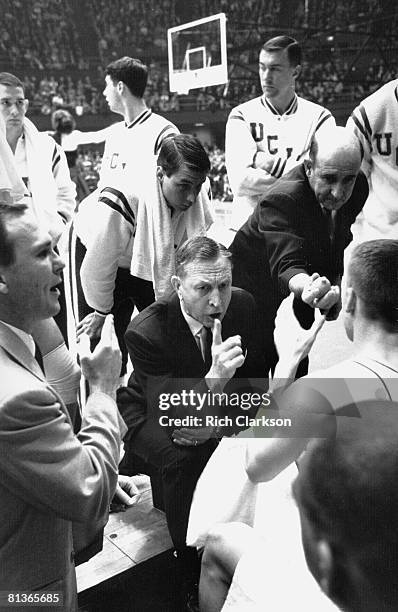 College Basketball: NCAA Final Four, UCLA coach John Wooden in huddle with team during timeout of game vs Duke, Assistant coach handing out lemons,...