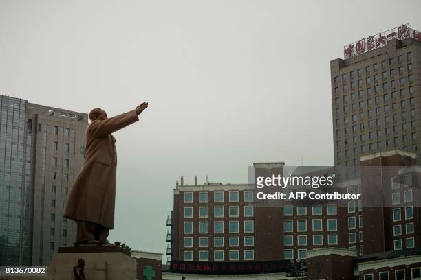 Picture taken on July 13 shows a statue of late communist leader Mao Zedong facing the First Hospital of China Medical University where China's Nobel...