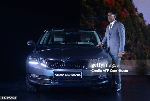 Director of Sales, Service and Marketing at SKODA Auto India Ashutosh Dixit poses for a photograph alongside the new SKODA Octavia model during the...