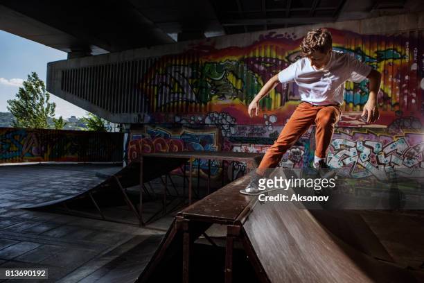 skater jumping on his skate in skatepark - dare devil stock pictures, royalty-free photos & images