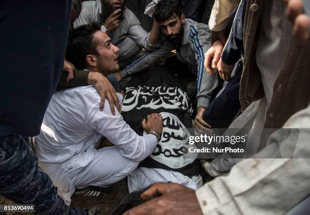 Kashmiri people touch the body of a local rebel Sajad Gilkar, during during his funeral Wednesday, July 12, 2017 in Srinagar, Indian-administered...