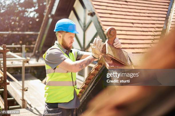 sostituzione di vecchie piastrelle - costruttore di tetti foto e immagini stock