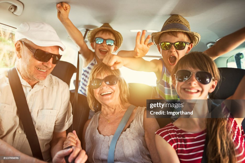 Grandparents having fun on road trip with grandchildren