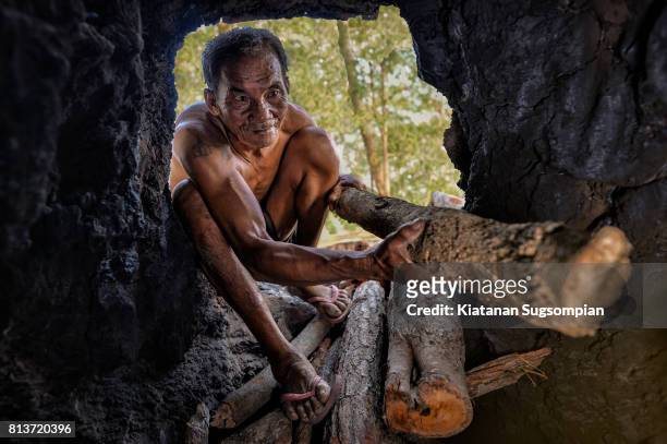 wooden charcoal making - caveman stock-fotos und bilder