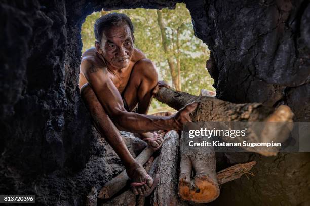 wooden charcoal making - cave man foto e immagini stock