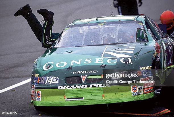 Auto Racing: NASCAR Carolina Dodge Dealers 400, Crew member of Stacy Compton jumping into car during pitstop to fix problem, Darlington, SC 3/17/2002