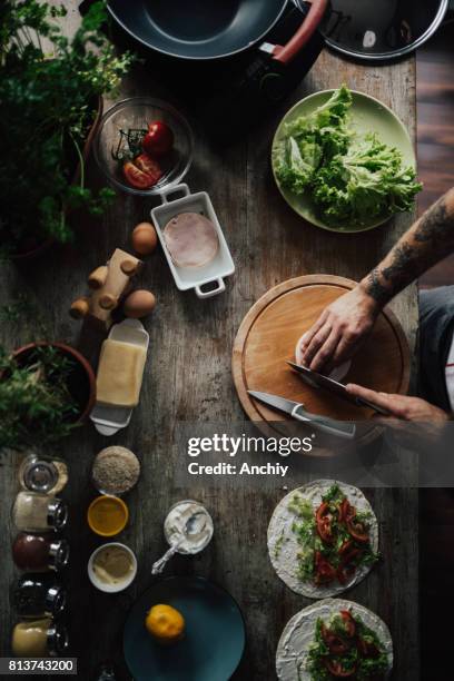 la cocina es el centro de la casa - hombre cortando queso fotografías e imágenes de stock