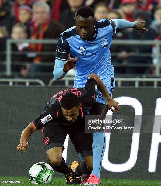 Arsenal's Francis Coquelin and Sydney FC's Charles Lokolingoy fight for the ball during a pre-season football friendly match against Sydney FC on...
