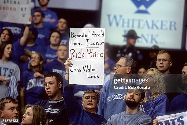 Coll, Basketball: Kentucky fan with BENEDICT ARNOLD, JUDOS ISCARIOT, RICK PITINO, JOHN WALKER LINDH sign during game vs Louisville coach Rick Pitino,...