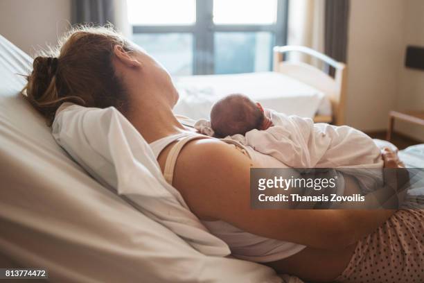 mother with her newborn baby in the hospital - sala de maternidad fotografías e imágenes de stock