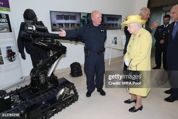Queen Elizabeth II and Prince Philip, Duke of Edinburgh are shown a bomb disposal robot during the opening of the the new headquaters of the...