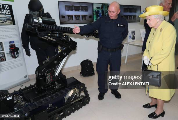 Britain's Queen Elizabeth II is pictured with a bomb disposal robot during a visit to open the new headquarters of the Metropolitan Police, New...