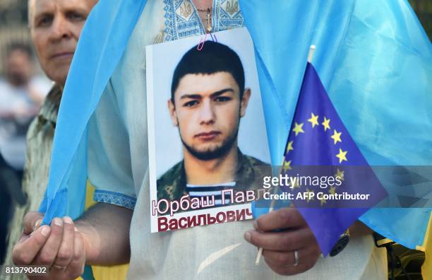 Relatives of Ukrainian servicemen jailed by pro-Russian separatists on the east of the country hold their portrets as they picket the Ukraine-EU...