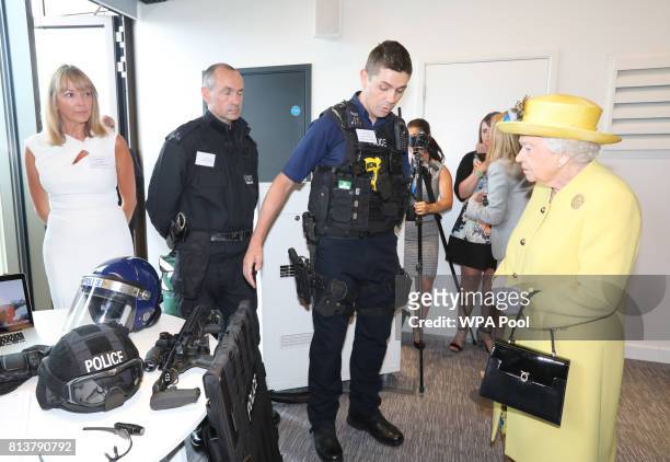 Queen Elizabeth II is shown police equipment during the opening of the the new headquaters of the Metropolitan Police Service on July 13, 2017 in...