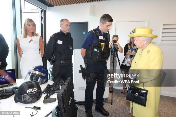 Queen Elizabeth II is shown police equipment during the opening of the the new headquaters of the Metropolitan Police Service on July 13, 2017 in...