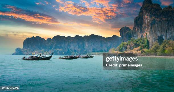 beautiful sunset at tropical sea with long tail boat in south thailand - phuket stock pictures, royalty-free photos & images