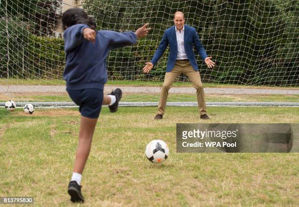 Prince William, Duke of Cambridge takes his turn in goal up against a member of the Wildcats Girl' Football programme during a kick-about with the...