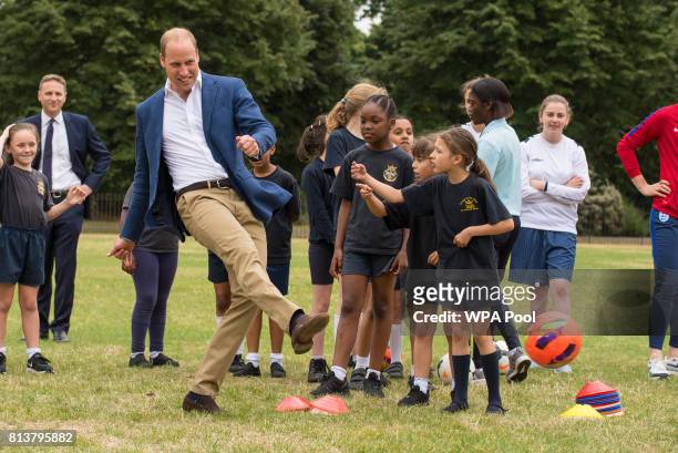 Prince William, Duke of Cambridge takes a shot at goal as he attends a kick-about with the Lionesses and local girls team from the Wildcats Girl'...