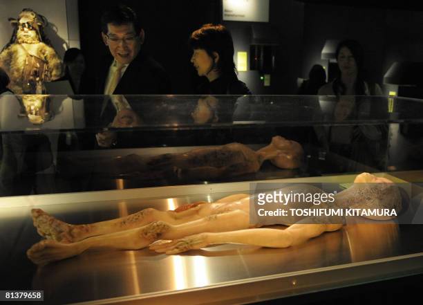 Visitors look at a model depicting the 1947 Alien Autopsy in Roswell, New Mexico during the "The Science of Aliens" exhibition at the Miraikan, the...