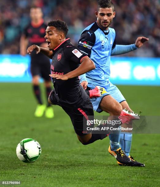Arsenal player Donyell Malen battles for the ball with Sydney FC player Nicola Kuleski in their football friendly played in Sydney on July 13, 2017....