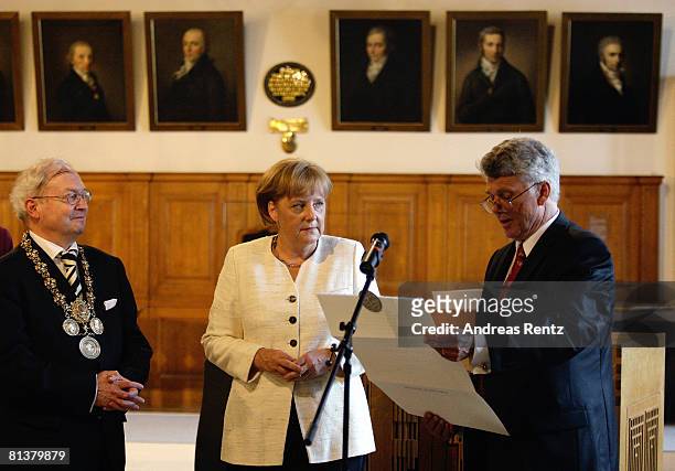Franz Haeuser , rector of the University Leipzig looks on as German Chancellor Angela Merkel listens to Tilman Butz , dean of the faculty for physics...