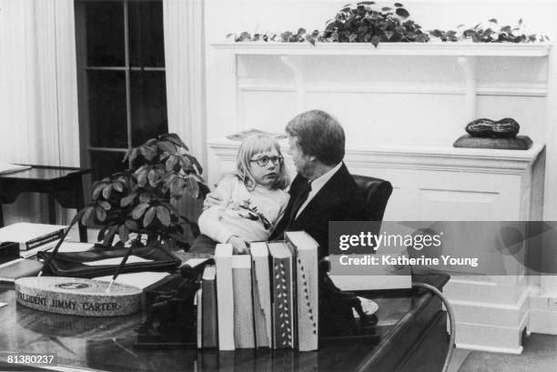 American President Jimmy Carter talks with his daughter Amy, who sits on his lap, in the Oval Office of the White House, Washington DC, 1978.