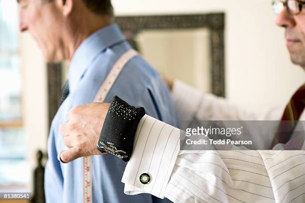 tailor measures man's shoulders - personal tailor stock pictures, royalty-free photos & images