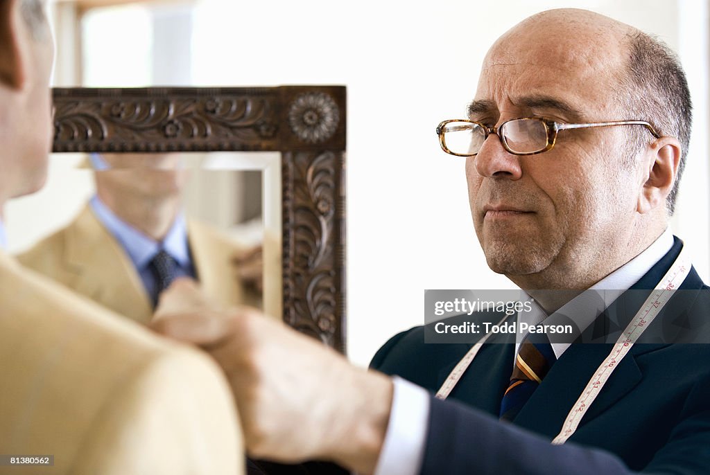 Tailor checks lapel of tan jacket