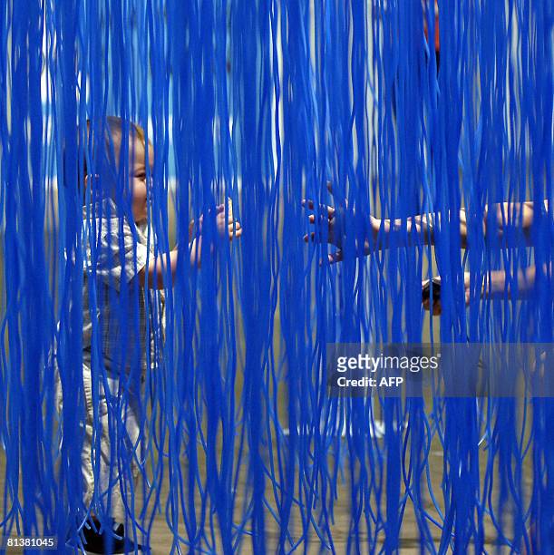 Baby visitor passes inside Jesus Raphael Soto's artwork called "Penetrable bbl bleu" on June 3, 2008 during the preview day of the Art 39 Basel fair...