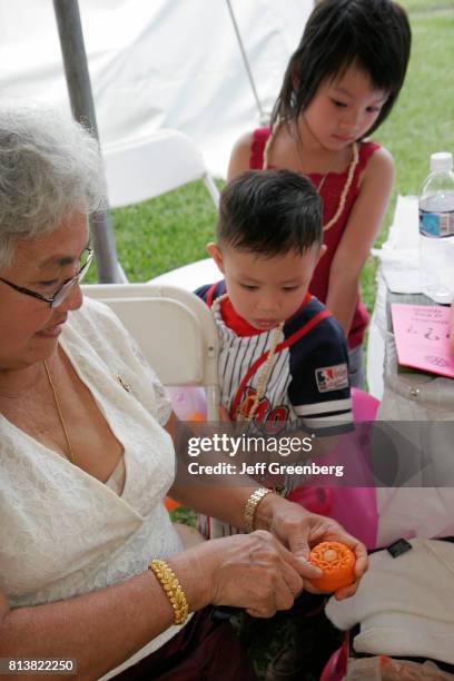 Children learn how to carve fruit at the Asian Culture Festival.