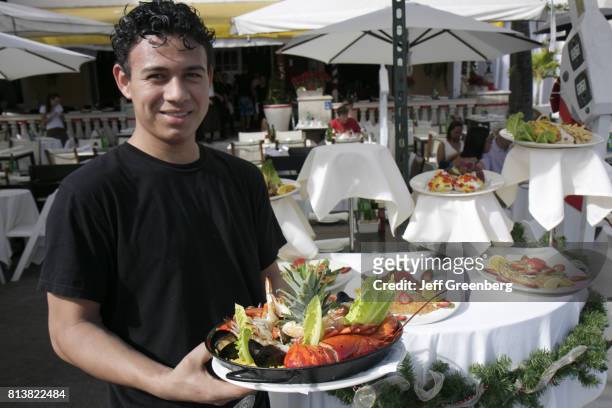 Waiter with a plate of food from Rendezvous on the Beach.