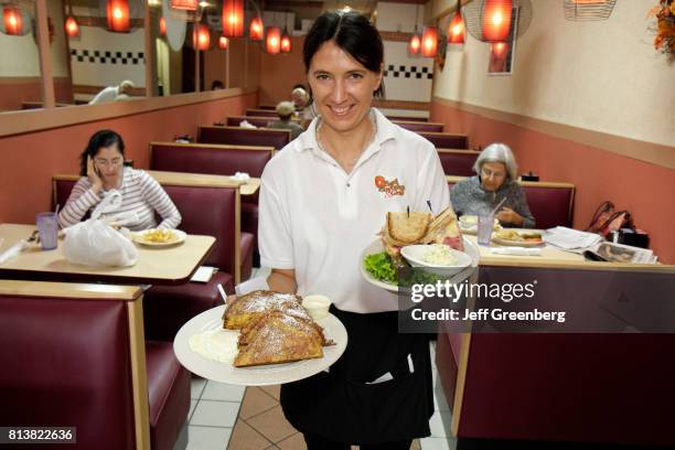 Waitress serving food at the Bagel Emporium and Grille.
