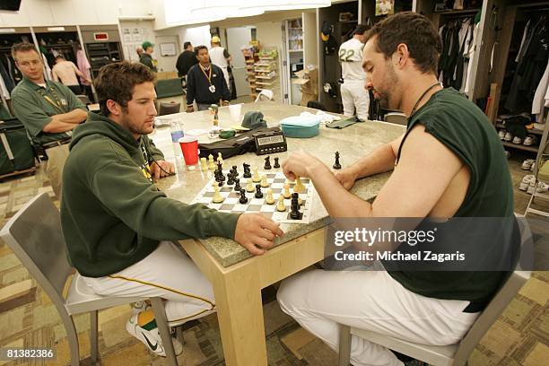 Huston Street of the Oakland Athletics plays chess with Andrew Brown of the Oakland Athletics in the clubhouse prior to the game against the Texas...