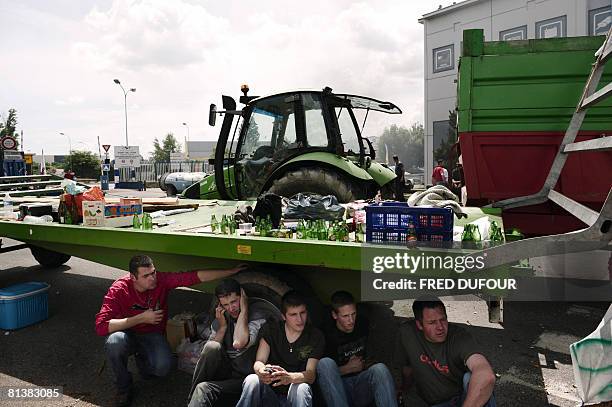 French farmers sit in front of a blockade at the entry of the Edouard Heriot port, France's biggest fluvial harbor, on June 3, 2008 in Lyon, central...