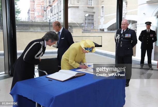 Queen Elizabeth II is watched by Commissioner of the Metropolitan Police Cressida Dick and Deputy Commissioner of the Metropolitan Police Craig...