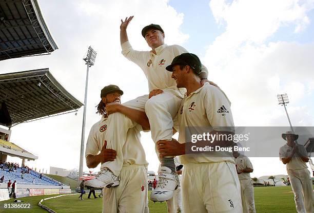 Stuart MacGill of Australia waves to the crowd as he is carried off the field by Andrew Symonds and Mitchell Johnson after day five of the Second...