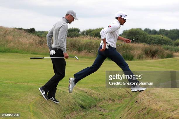 Rafa Cabrera-Bello of Spain and Martin Kaymer of Germany cross a ditch on the 9th hole during day one of the AAM Scottish Open at Dundonald Links...