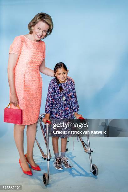 Queen Mathilde of Belgium pose with a girl during a photoshoot during her visit to the editorial rooms of Belgium's oldest women's magazines Libelle...