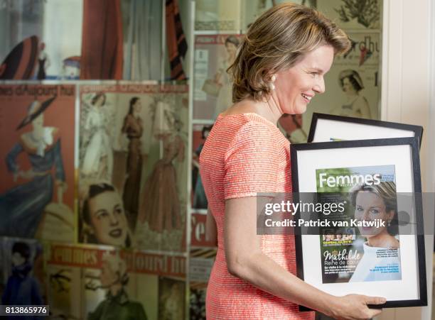 Queen Mathilde of Belgium with a cover of herself during her visit to the editorial rooms of Belgium's oldest women's magazines Libelle and Femme...