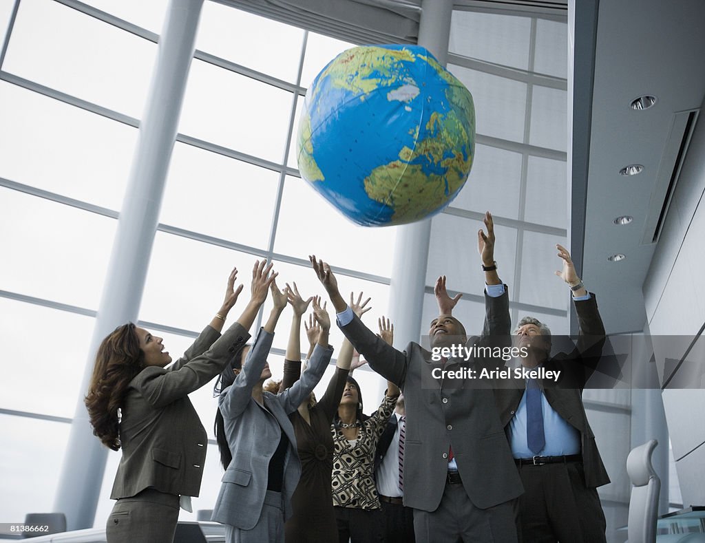 Multi-ethnic businesspeople playing with globe ball