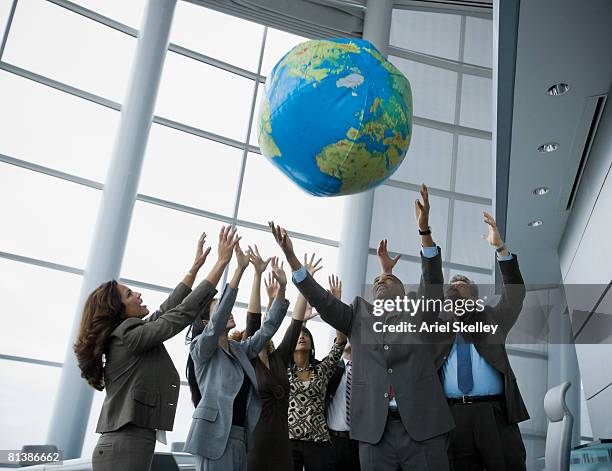 multi-ethnic businesspeople playing with globe ball - team building stock pictures, royalty-free photos & images