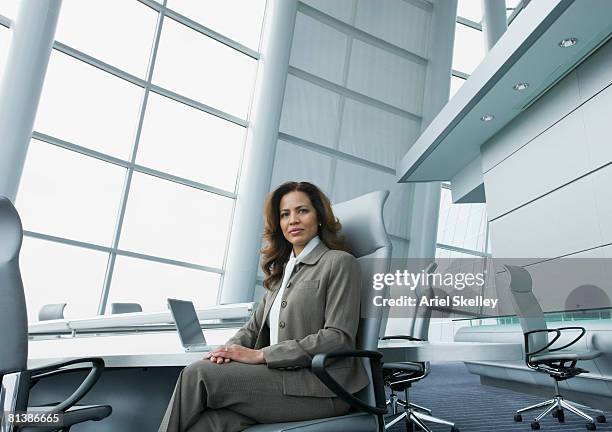 hispanic businesswoman at conference table - altos cargos directivos fotografías e imágenes de stock